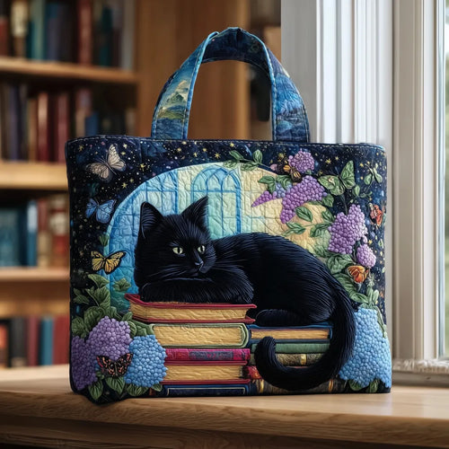 Artisan quilted tote bag with the Black Cat and Old Books design, a watchful black cat beside a leaning tower of leather-bound books.