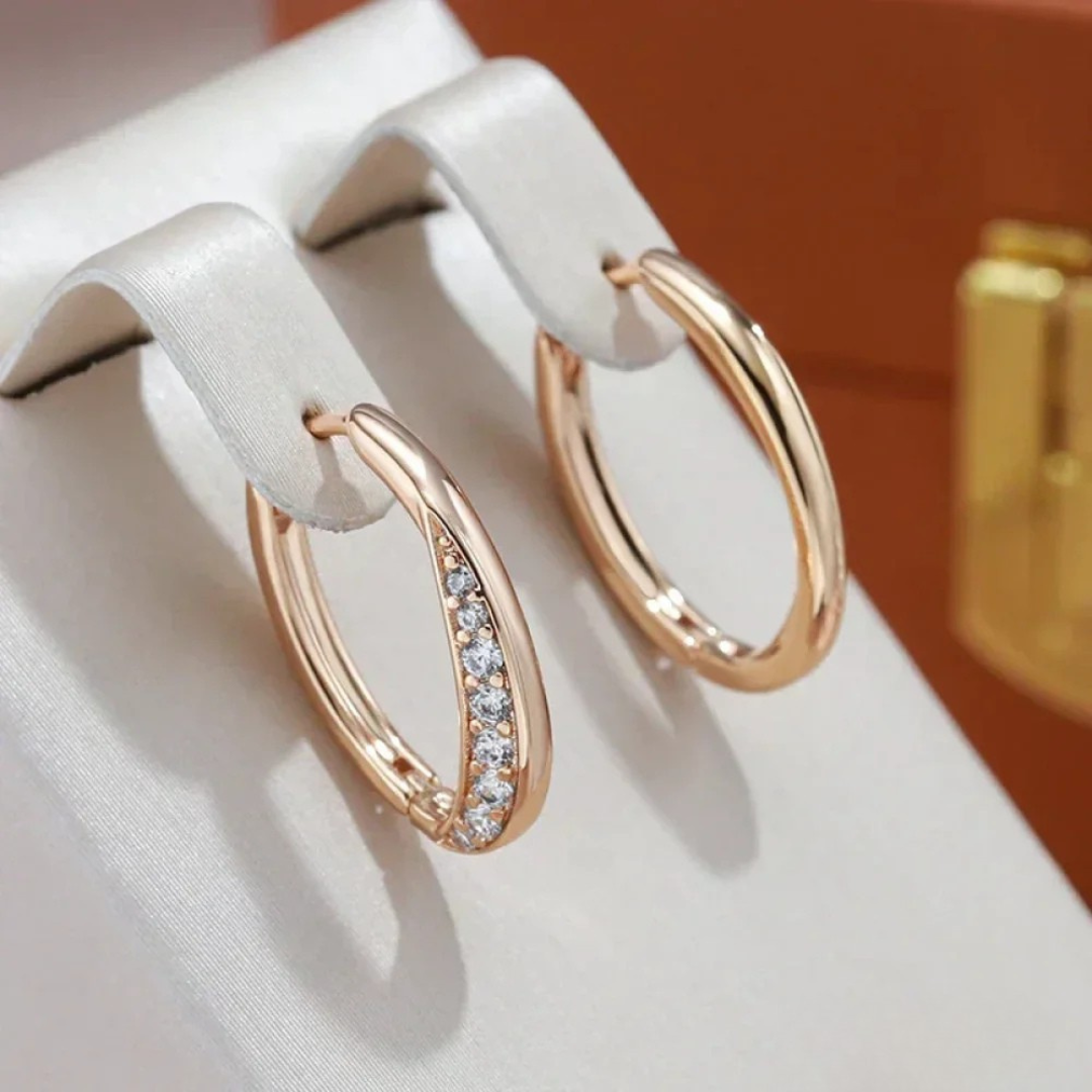 Rose-gold-tone oval hoop earrings with a line of crystals