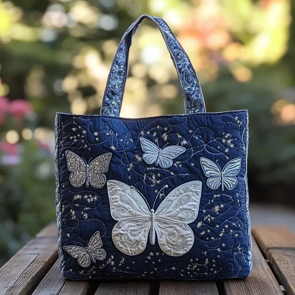 Artisan quilted tote bag with a silver butterfly, wings open and markings worked in pale thread
