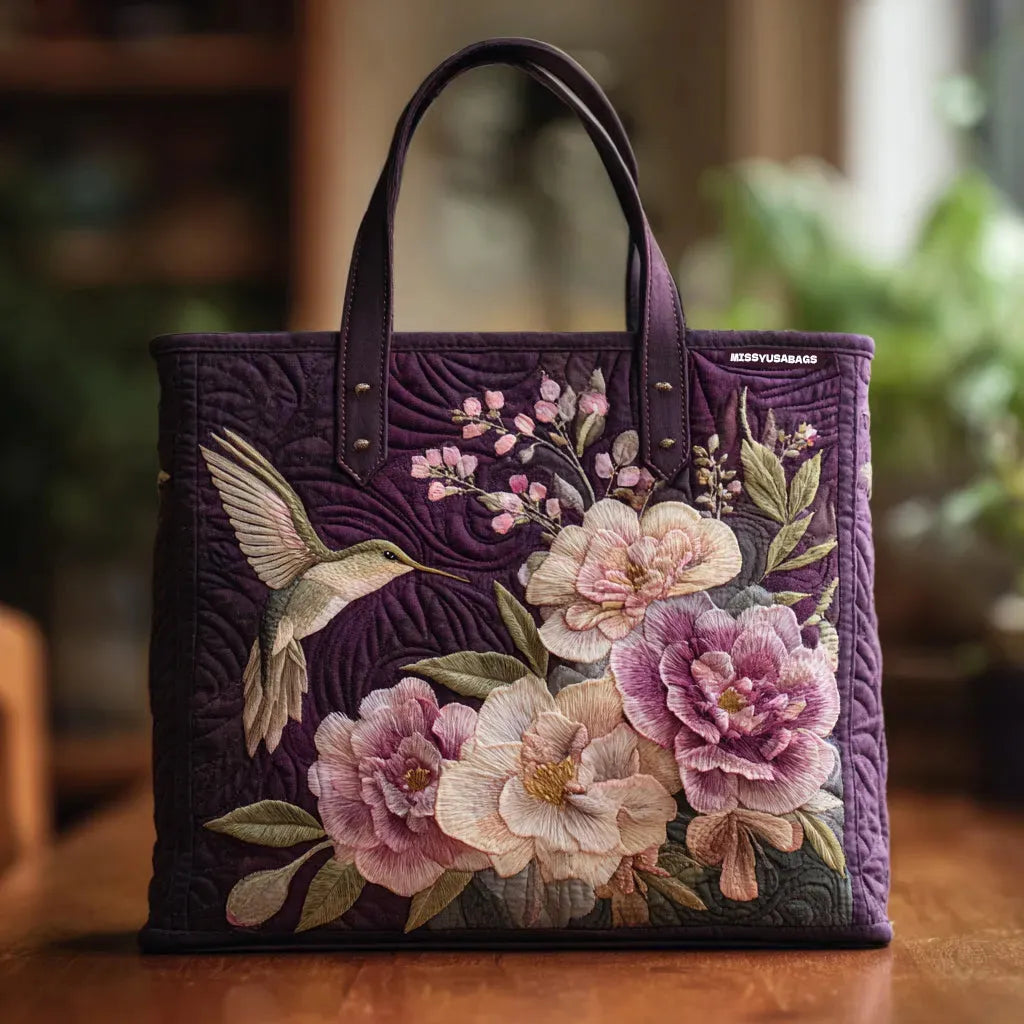 Artisan quilted tote bag with the Hummingbirds and Orchids design, hummingbirds in flight beside pink and violet orchids.