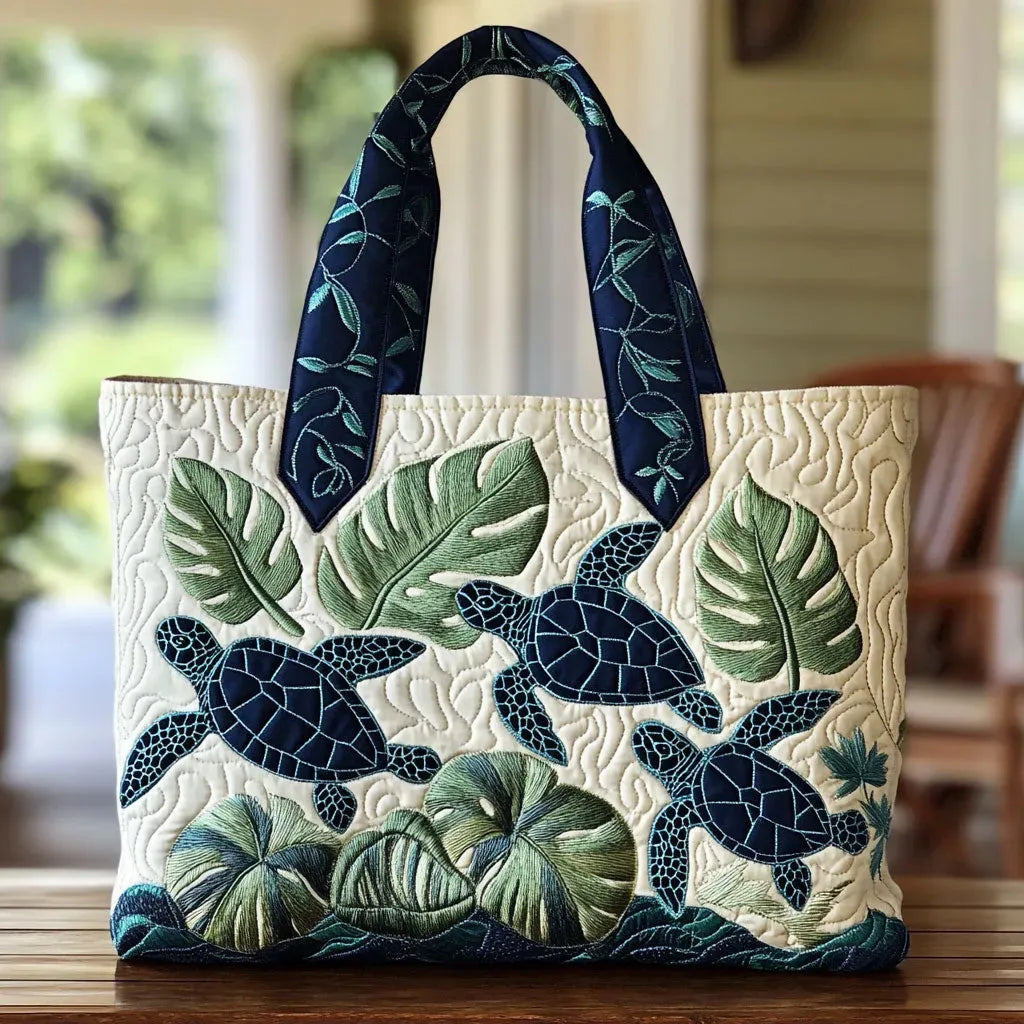 Artisan quilted tote bag with a single sea turtle gliding through drifting blue water and soft coral shapes