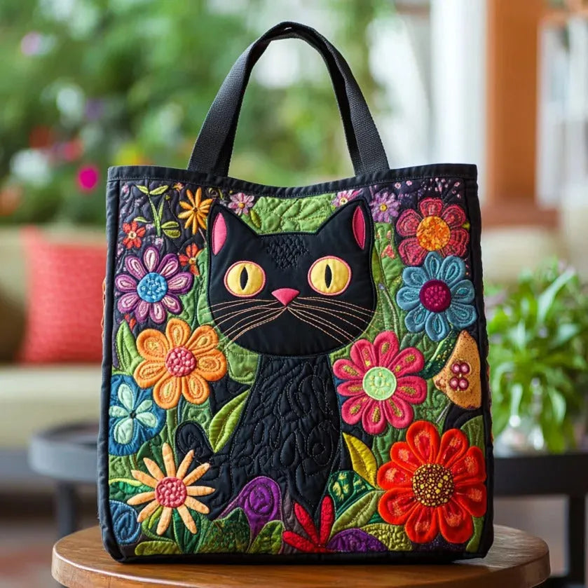 Artisan quilted tote bag with a black cat seated beneath a crescent moon and scattered stars in deep night blue and silver