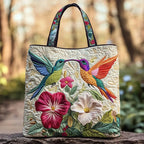 Artisan quilted tote bag with a hummingbird hovering beside a single open white bloom