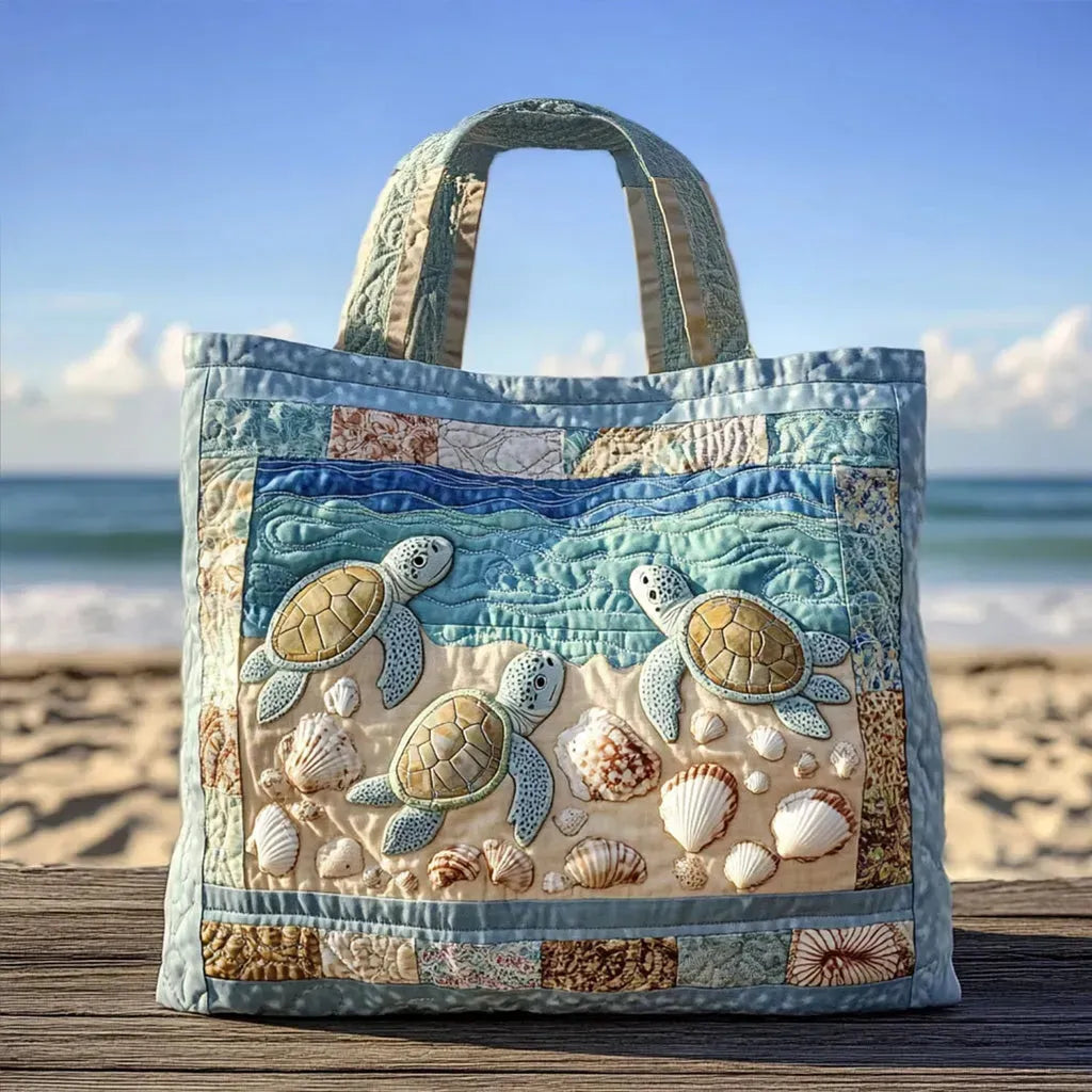 Artisan quilted tote bag with several sea turtles of different sizes swimming together through deep blue water and pale seagrass