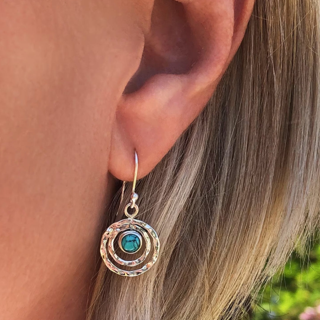 Drop earrings with a turquoise-blue stone in layered rings