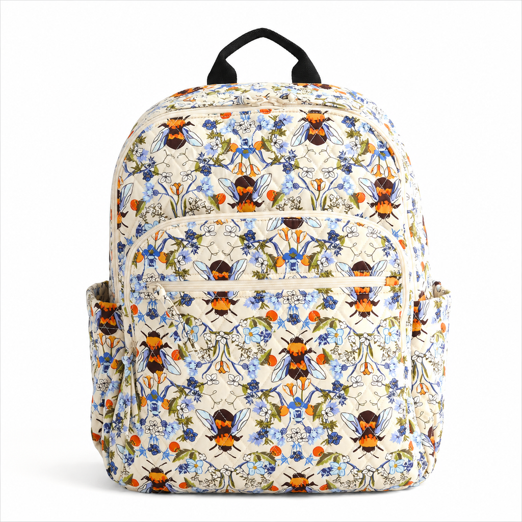 Artisan quilted backpack with bees moving amongst open flowers and leaves in gold and soft petal tones