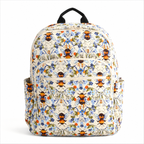 Artisan quilted backpack with bees moving amongst open flowers and leaves in gold and soft petal tones