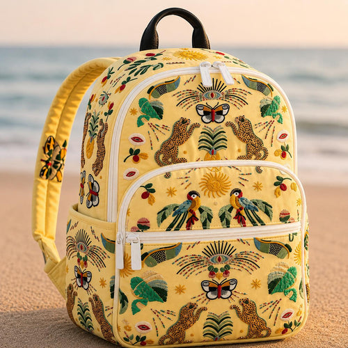 Artisan quilted backpack with a spotted dalmatian standing amongst summer garden flowers in full bloom