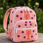 Artisan quilted backpack with a camper van and stacked books against a warm sunset sky