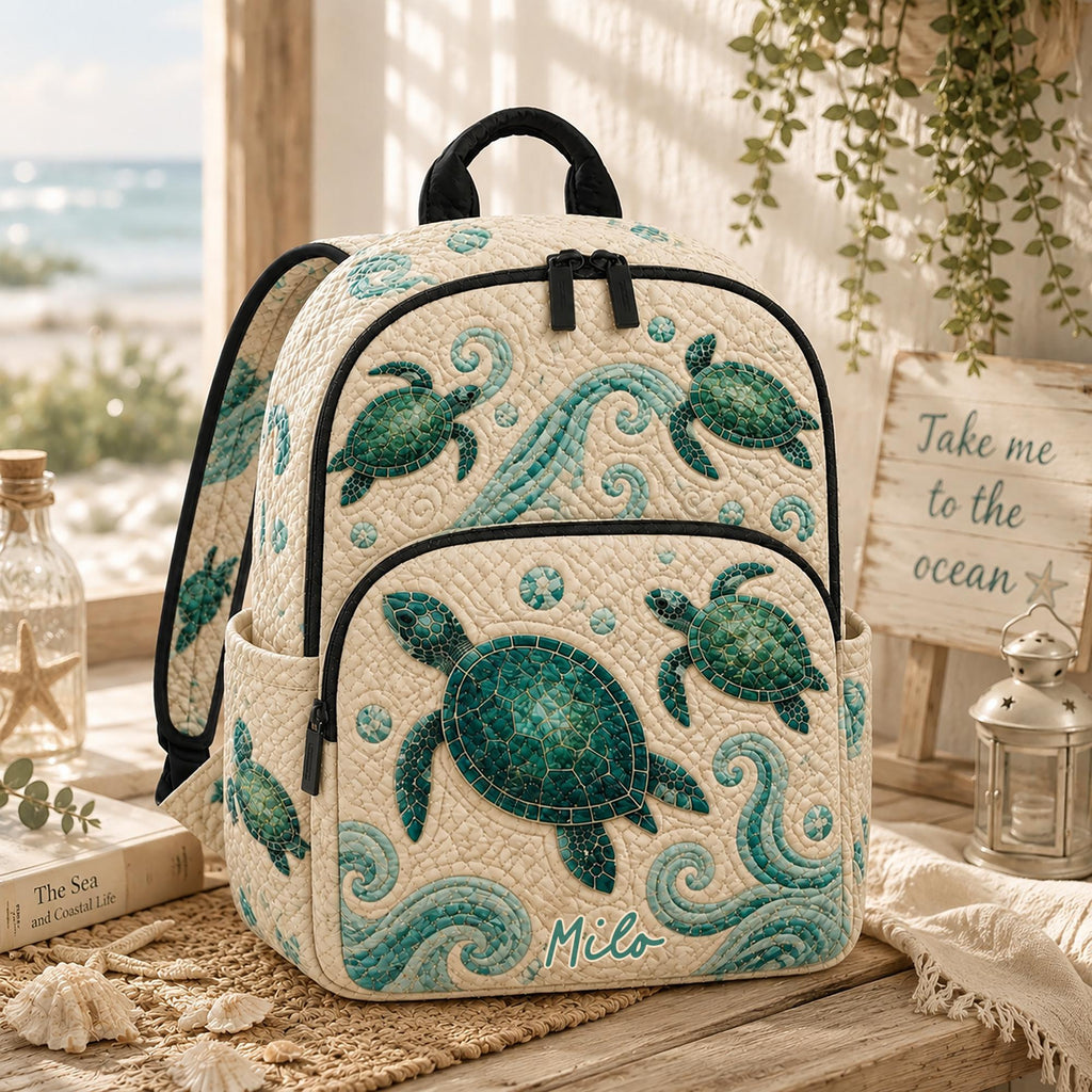 Artisan quilted backpack with a green sea turtle swimming through deep blue water across the quilted front panel