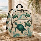 Artisan quilted backpack with a green sea turtle swimming through deep blue water across the quilted front panel
