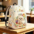 Artisan quilted backpack with a small dog sitting amongst soft garden flowers in gentle blooming shades