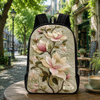 Artisan quilted backpack with broad magnolia blooms layered against dark green leaves across the front