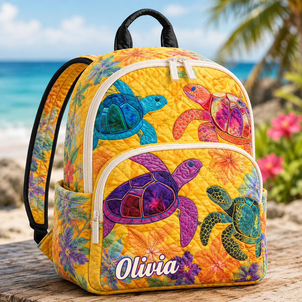 Artisan quilted backpack with a yellow sea turtle swimming in tropical blue water across the quilted front panel