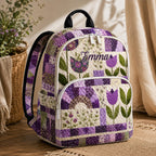 Artisan quilted backpack with a purple floral patchwork design of mixed flowered squares in lilac and plum