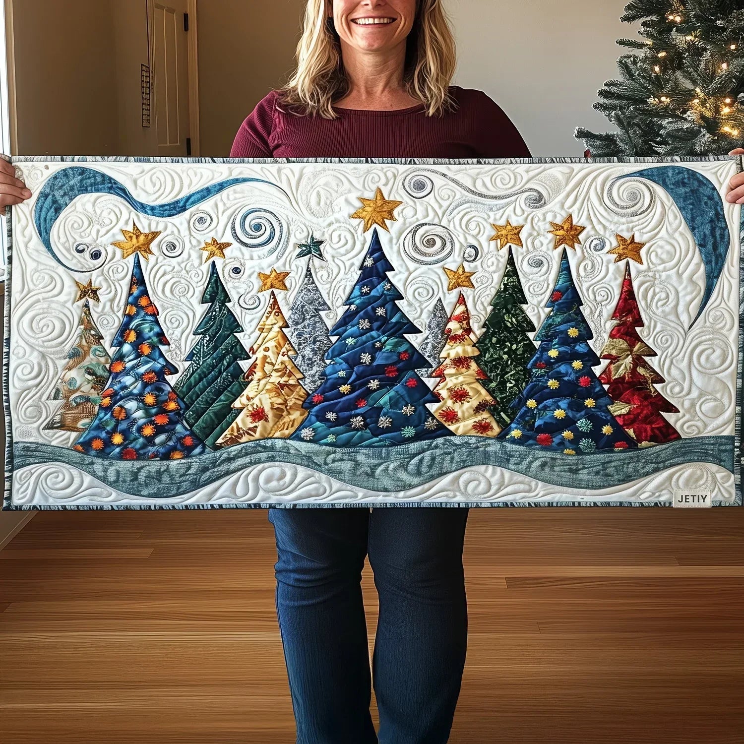 Quilted table runner with snow-covered pine trees across a still winter landscape in green and white