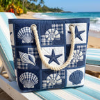 Quilted beach bag with the Serenity of Shells design, pale shells in fine outline evenly spaced on a chalky ground in oyster, driftwood grey and soft blush, standing upright