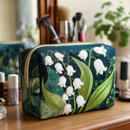 Quilted make-up bag with open lilies in cream and blush, with curling petals and slim green leaves, in the Lily Grace design