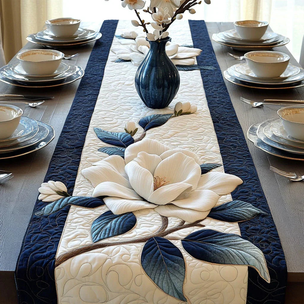Quilted table runner with pale magnolia flowers on slender branches against a soft ground