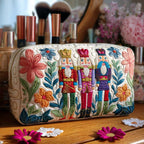 Quilted make-up bag with small nutcrackers scattered in a repeating pattern amongst tiny baubles, stars and pine sprigs in red, cream and gold in the Nutcracker Charm design