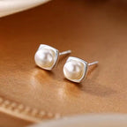 Faux pearl stud earrings in a square silver-tone setting