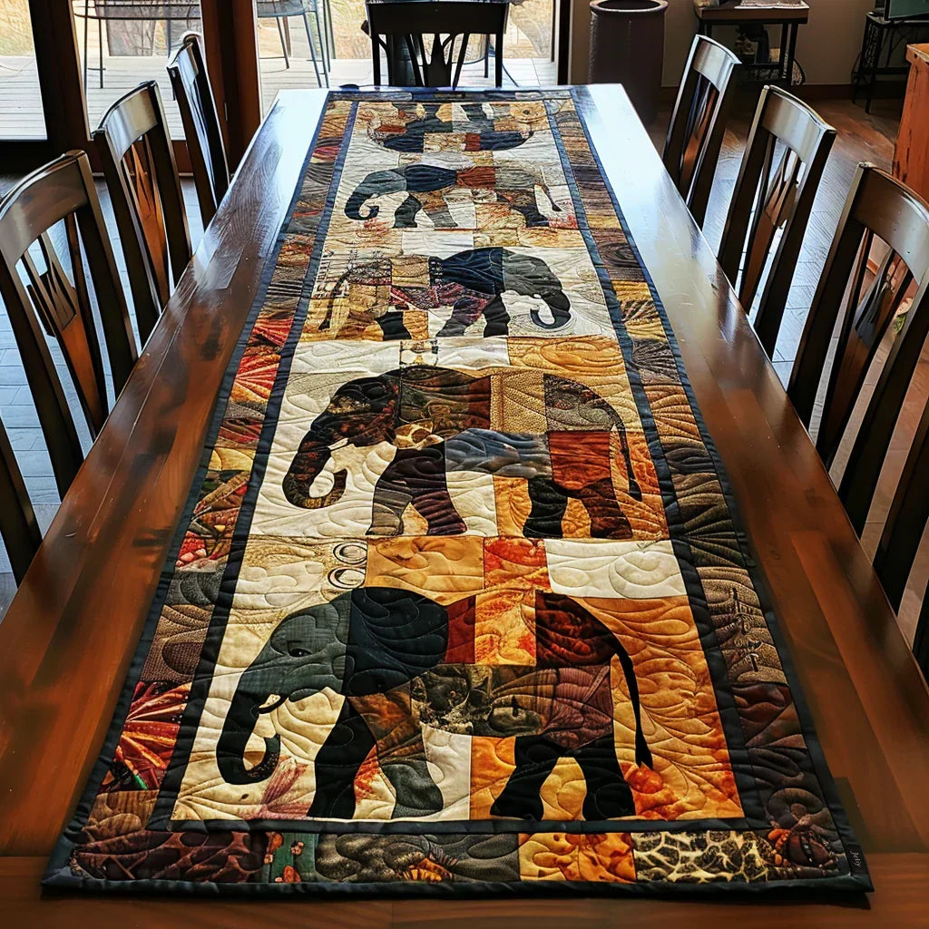 Quilted table runner with an Elephant March design of elephants walking nose to tail in patterned cloth and warm jewel colours