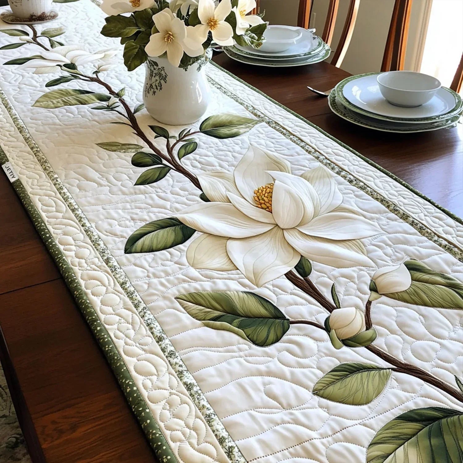 Quilted table runner with cream and rust magnolia blooms on a weathered wood-grain background