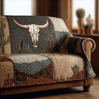 Sagebrush Longhorn quilted sofa cover with a bone-white longhorn skull on slate green, cacti and desert mesas in rust and sand