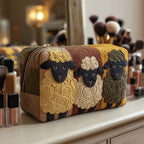 Sheep Trio quilted make-up bag with three woolly sheep with black faces on mustard and olive