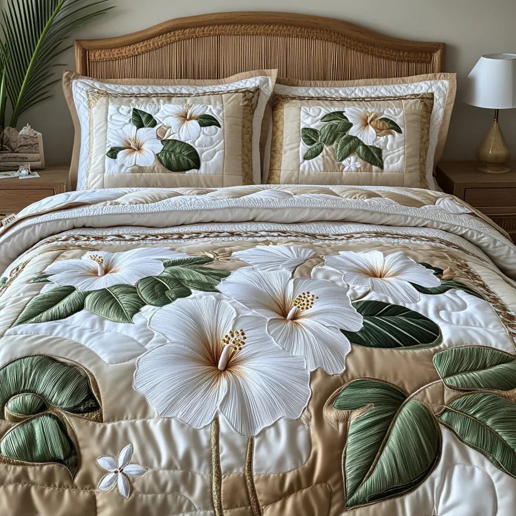 Quilted bedspread set with large white hibiscus blooms and soft green foliage on a pale ground, the White Hibiscus design