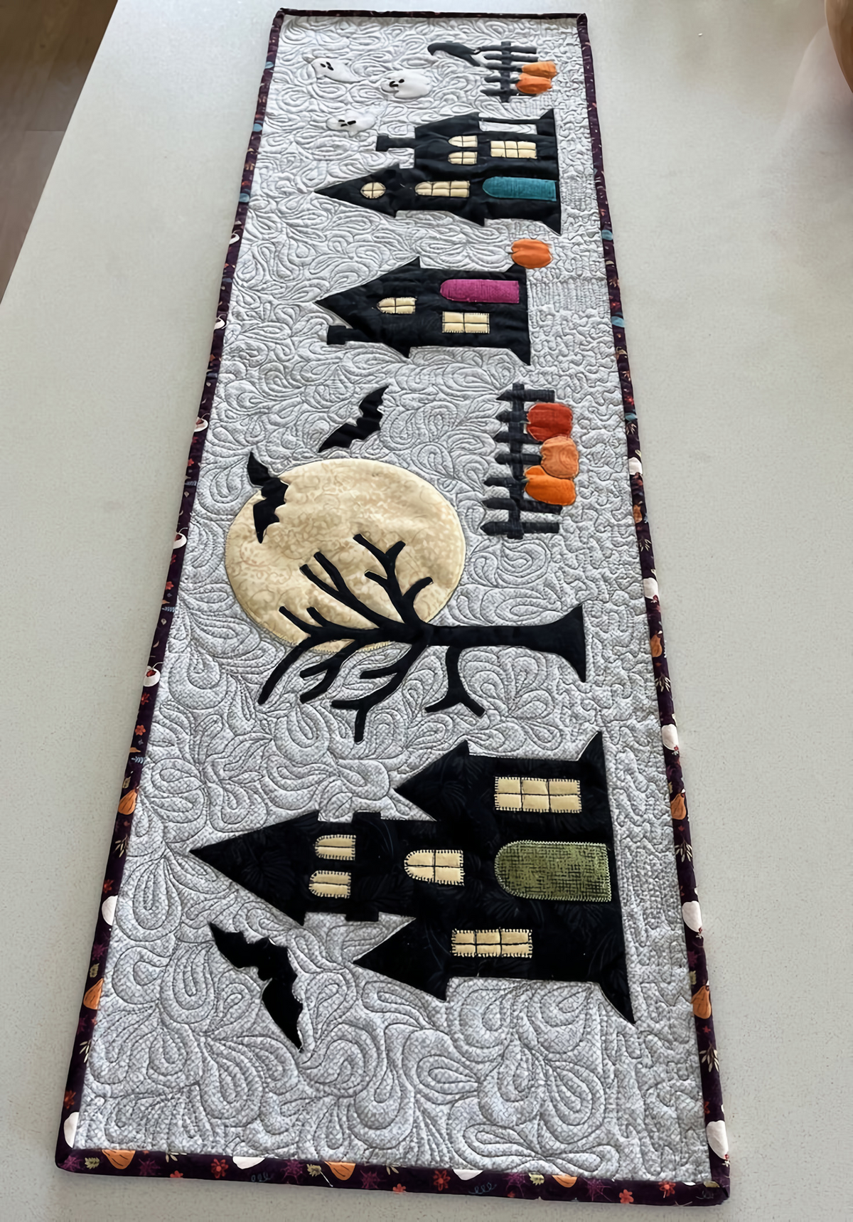Spooky Silhouettes quilted table runner – haunted houses and bats on grey