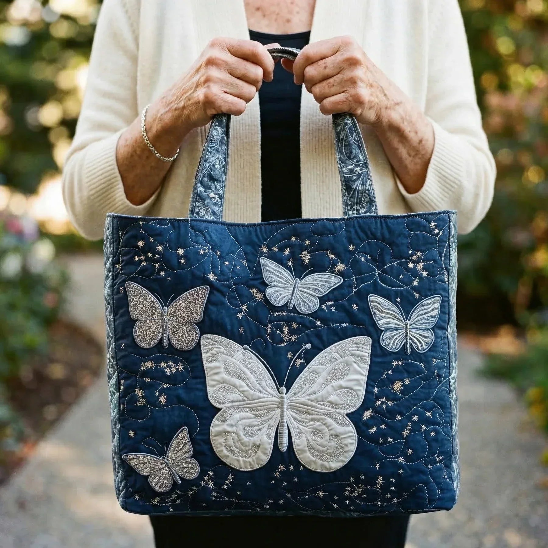Woman carrying the Silver Butterfly artisan quilted tote bag