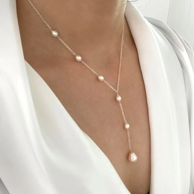 Pearl lariat drop necklace worn with an open collar