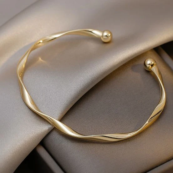 Twisted polished gold-tone open bangle