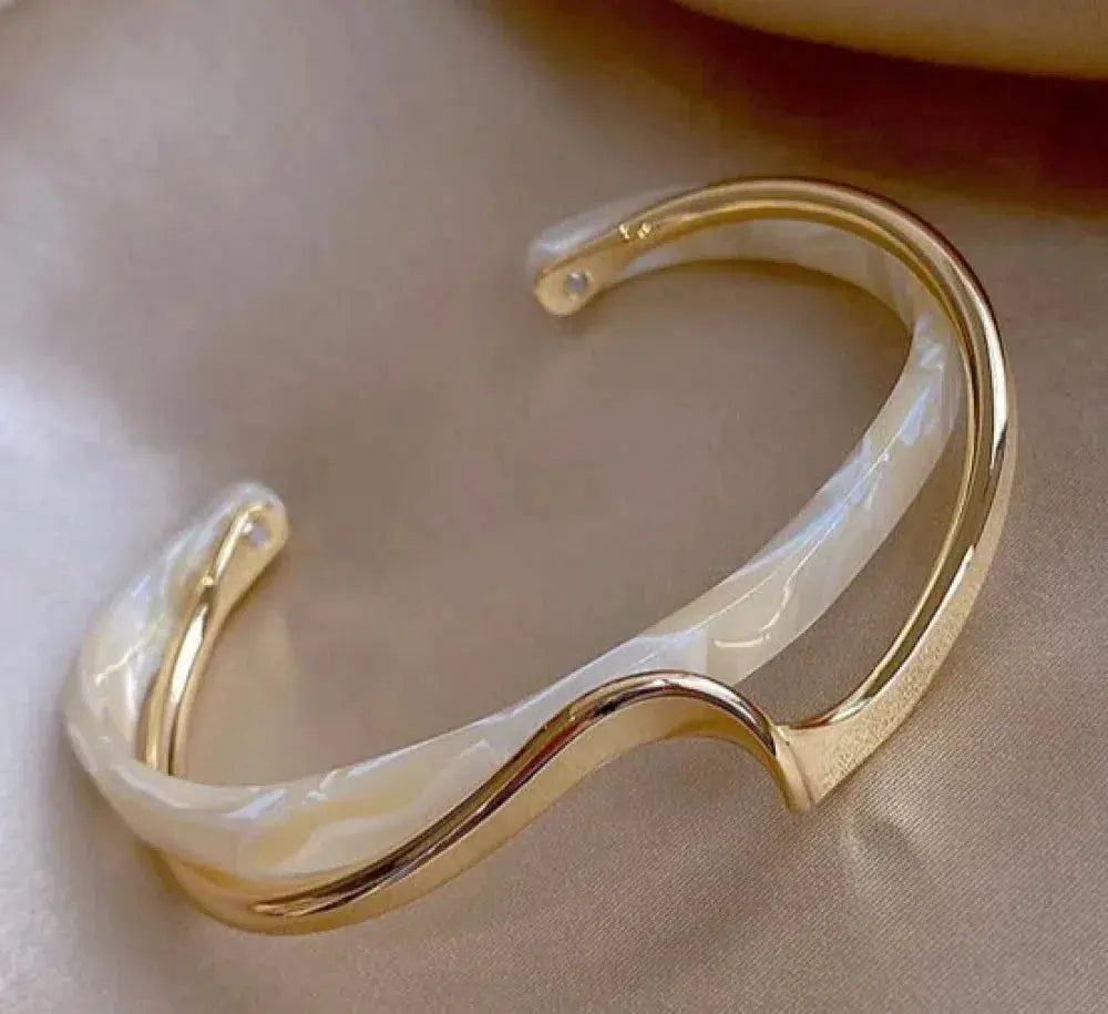 Gold-tone cuff with white opal-effect enamel